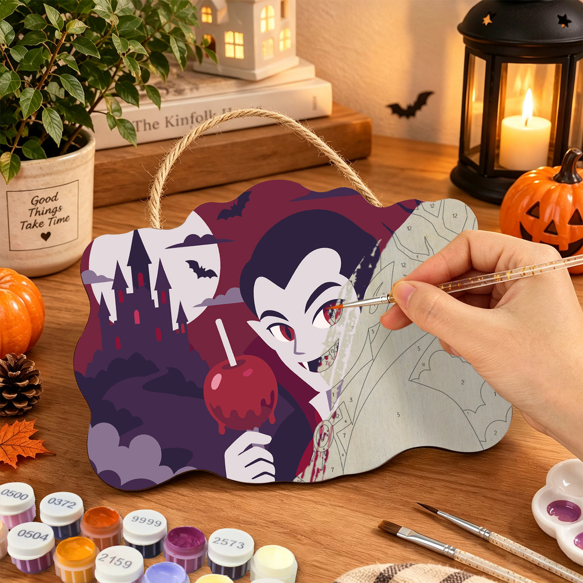 Pancarte Vampire et Pomme d'Amour en cours de peinture, pinceau à la main — Maison Artsen